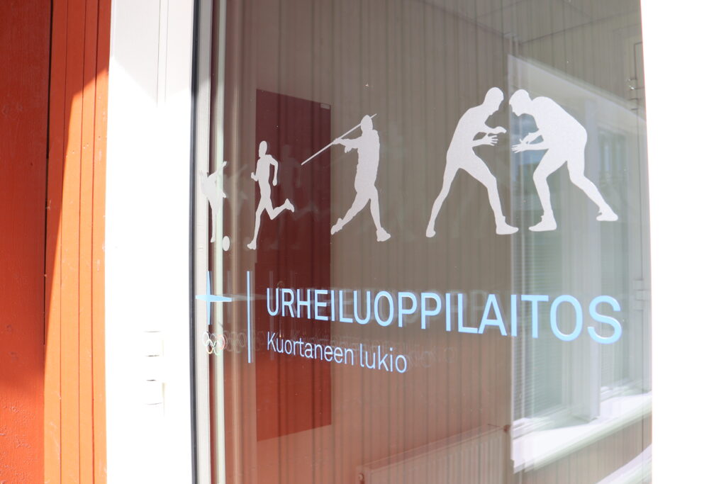 Kuortaneen lukion ulko-ovi- Ovessa teksti urheiluoppilaitos.