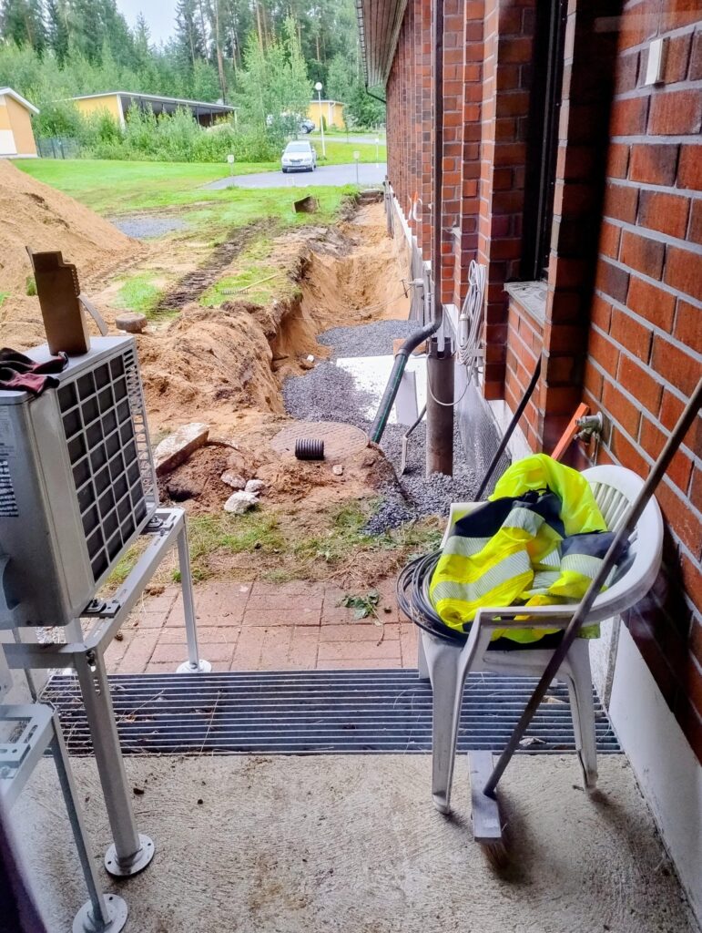 Tiilitalon reunustaa kaivettu auki rakennuksen salaojiatusta varten. 
