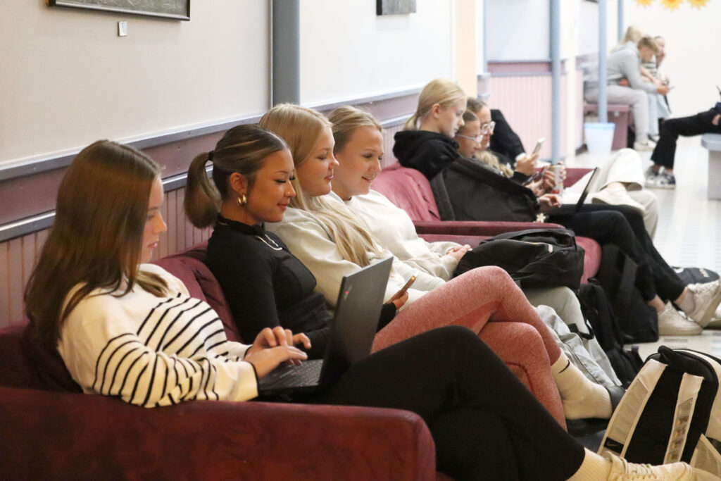 Lukiolaisia istumassa Kuortaneen lukion käytävällä sohvalla